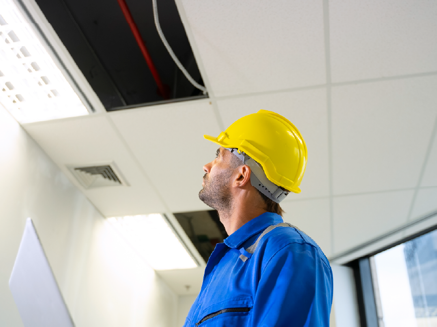 Operaio intento a guardare un impianto al soffitto